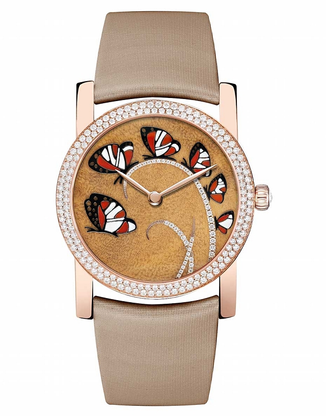 Six carnelian butterflies flutter across a precious myrtle burl wood background. Photo courtesy Chaumet.