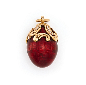 Lot 46 boasts a red enamel egg pendant topped by diamond-bedecked gold scrolls.  