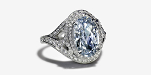 The Fancy Intense blue diamond in this wave ring was cut by hand. Accents of white diamonds surround it. 
