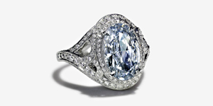 The Fancy Intense blue diamond in this wave ring was cut by hand. Accents of white diamonds surround it.